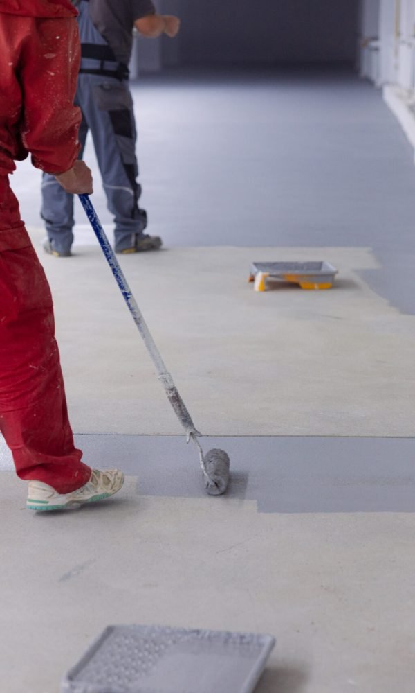 Painter applies heavy traffic gray resin in the factory