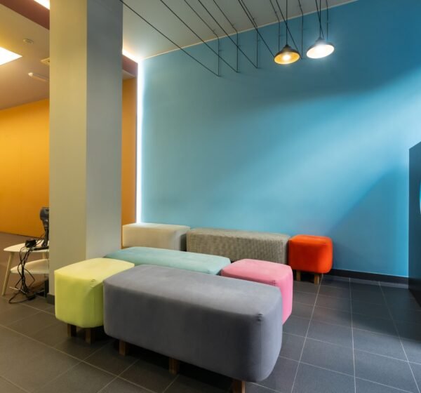 The Waiting room of a modern dental clinic with colored sofas